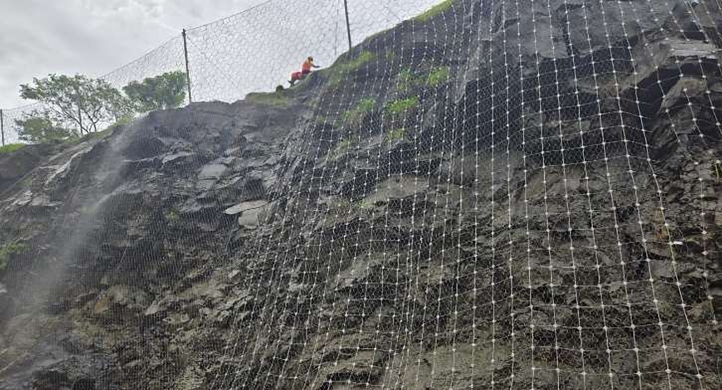 High-tensile mesh slope protection on a rock cut